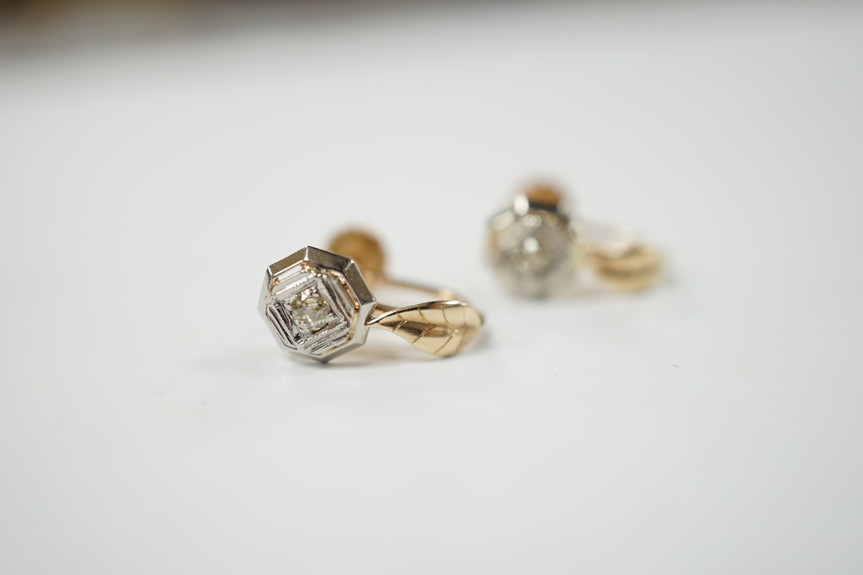 A pair of 14k gold and brilliant cut diamond earrings